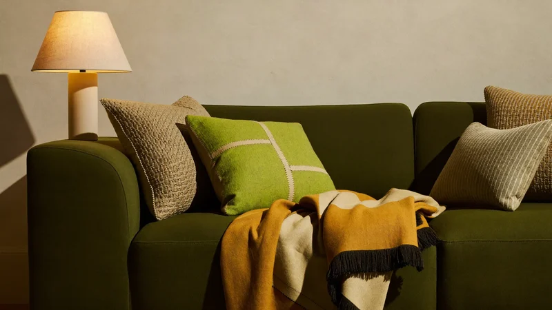 Sofaecke mit Kissen in Ocker, Olive und Creme im Lampenlicht